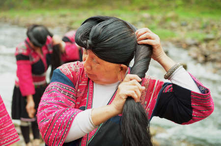 Longji, China - May 06, 2009: Women brush and style hair in Longji, China. Women of Red Yao people living in Longji Yao village circa Guilin, China have one of the longest hair in the world.のeditorial素材
