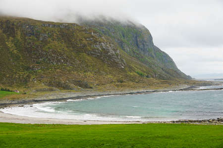 View to the seaside and mountains with low clouds and fog in Alnes, Norway.の写真素材