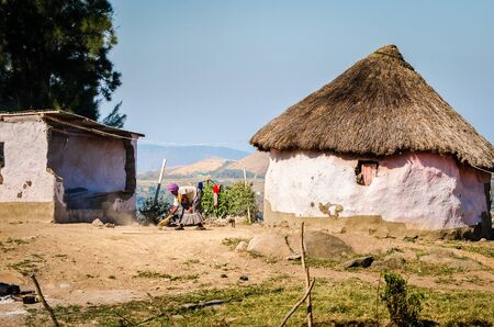 African woman cleaning garden near rural houses apartheid, KwaZulu Natal near Durban, august 2013. Pietermaritzburg South Africaのeditorial素材