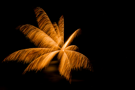 A golden fireworks burst in the night sky.の写真素材