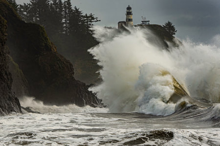 A King Tide wave crashing into the rock infront of the Cape Disappoinment Lighthouseの写真素材