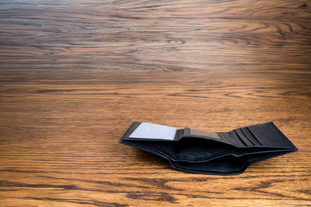 A Black, Empty Wallet sitting on a desktop.