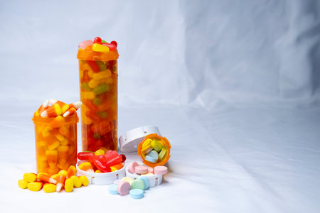 Three overfowing prescrption bottles that are filled with various candies. Cocept shown is drugs being prescribed and comsumed like they were candy instead of controlled substatnce.の写真素材