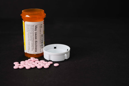 A prescription (RX) of medication in the form of pink pills. Some of the pills are outside of the bottle.の写真素材