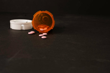 Some of the pills are spilled outside of the bottle.