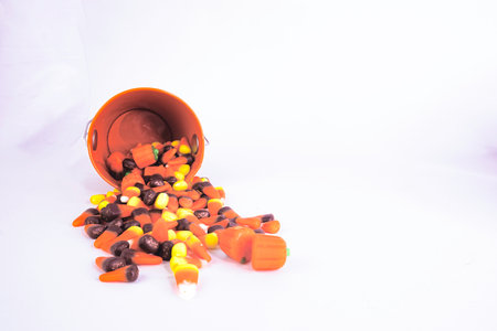 A bucket of Holloween candy spilled on to the surface. Viewed straight on.