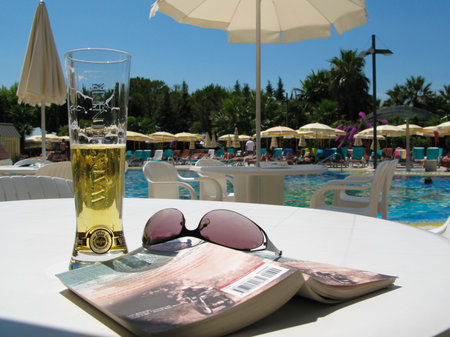 beer, book and sunglasses by the poolside のeditorial素材