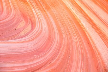 Pink and orange curved sandstone layers weathered by wind and water into beautiful shapes.