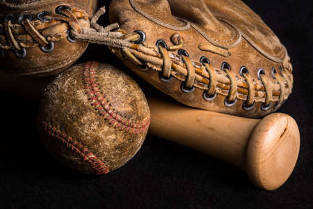 Contrast of old and new equipment with old mitt and ball joined by brand new baseball bat.の写真素材