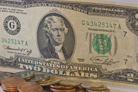 Closeup of Two Dollar Bill with scattered loose change in frontの写真素材