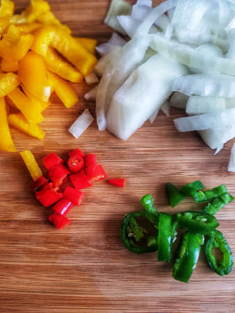 Chilli's with a yellow pepper and onion on a chopping boardの写真素材