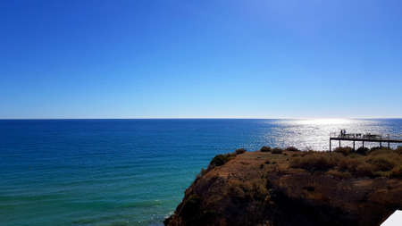 Albufeira Alemaes beach, a pier in the distance with fishermenの写真素材
