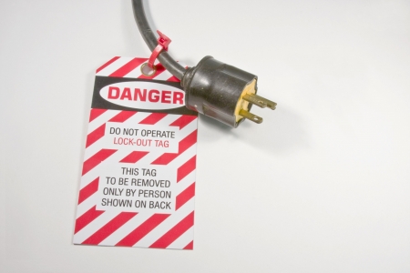 electrical lock out tag on an extesion cord over white