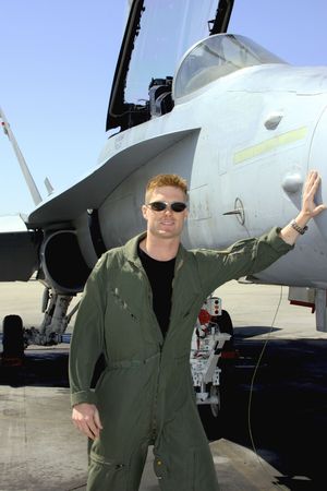 Navy pilot standing by his fighter jet
