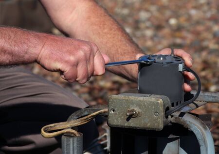 electrician repairs motor on a roof fanの写真素材