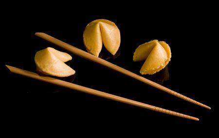 fortune cookies and chopsticks on a black backgroundの写真素材
