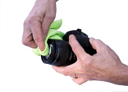 photographer cleaning a camera lens with a micro cloth isolated with a clipping path at original sizeの写真素材