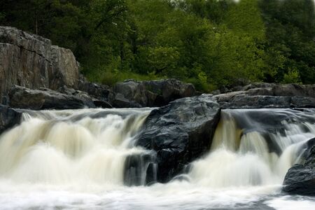 waterfall with blurred water flowing over rocks and boulders