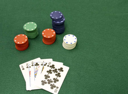 royal flush poker hand with chips and a green felt background