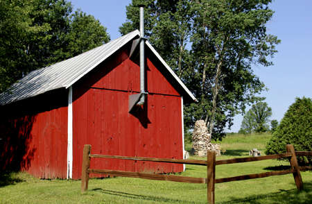old red country cabin with trees and grass in the backgroundのeditorial素材