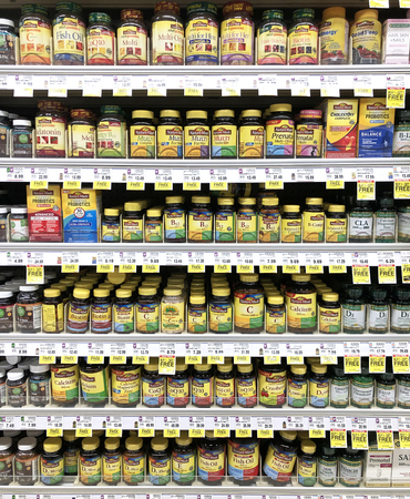 Several brands of Vitamins on a modern grocery store shelfのeditorial素材