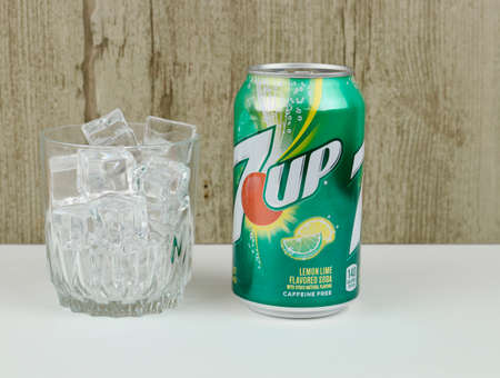 Spencer, Wisconsin, U.S.A. , March, 10, 2020,     Can of 7 Up and a glass of ice with a wooden...