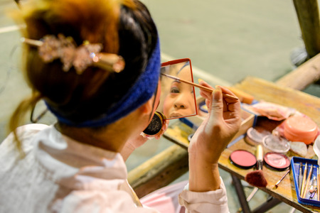 Hong Kong, China - August 18, 2014  A traditional opera actor is making up at the back stage of a traditional tea house in hongkong, China  Generally, an actor needs 30 - 60 minutes to complete the whole process のeditorial素材