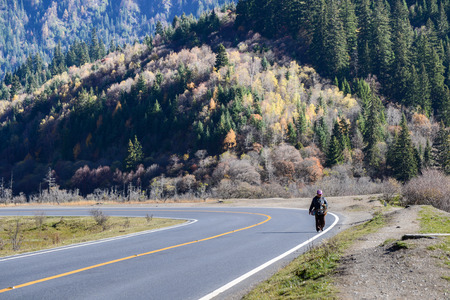 Jiuzhaigou, Sichuan, China - November 05, 2014 : Old woman take his herbal medicine on the highway roadside.のeditorial素材
