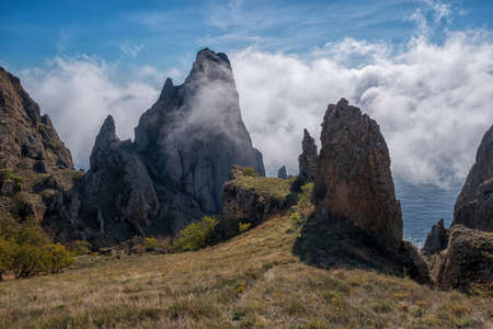Sea fog is moving on the rocks of the Kara-Dag volcanic mountain range in the Crimeaの写真素材