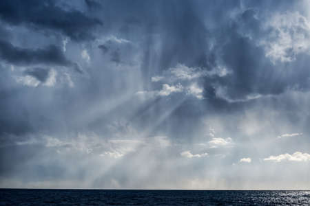 The sun's rays break through the rain clouds over the Black seaの写真素材