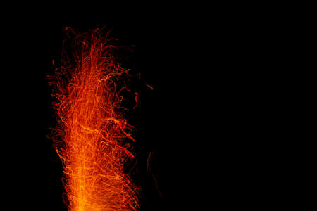 Fire sparks on a black background with a free spaceの写真素材