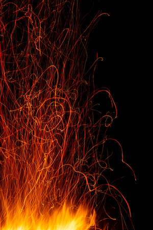 Long curved traces of sparks from the fire on a long exposure on blackの写真素材