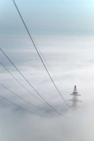 Power lines going into the fogの写真素材