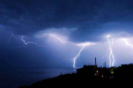 Powerful thunderstorm over a small townの写真素材