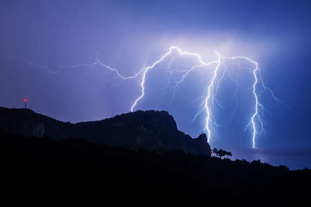 A powerful discharge of lightning over the black seaの写真素材
