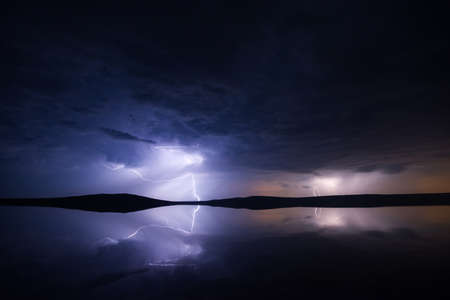Night thunderstorm over salt lake with reflectionの写真素材