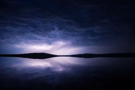Night thunderstorm over salt lake with reflectionの写真素材