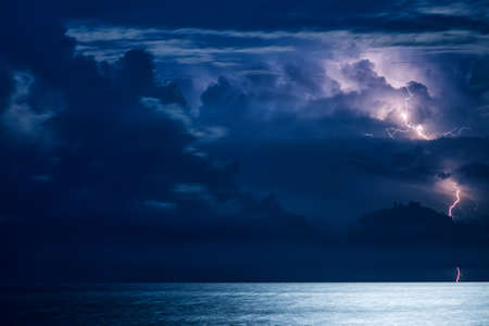 Massive cumulus clouds and lightning at night over the Black sea in Crimeaの写真素材