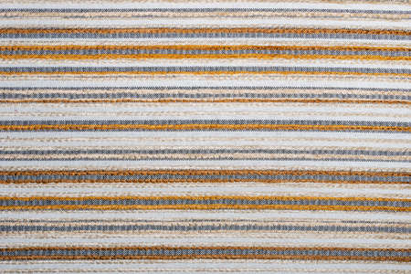 Detail view of decorative fabric texture with white, yellow, and black stripesの写真素材