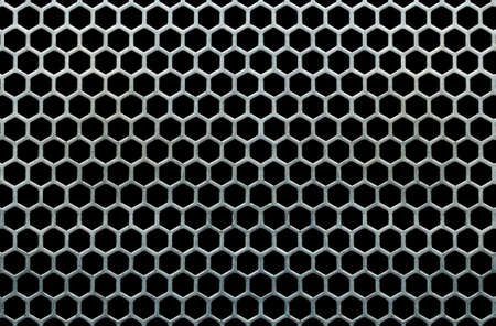 Metal grid with hexagonal cells on a black backgroundの写真素材