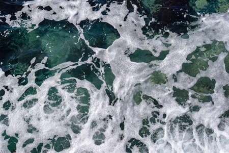 Sea foam on clear turquoise waterの写真素材