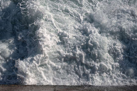 Sea foam top view from the concrete quayの写真素材