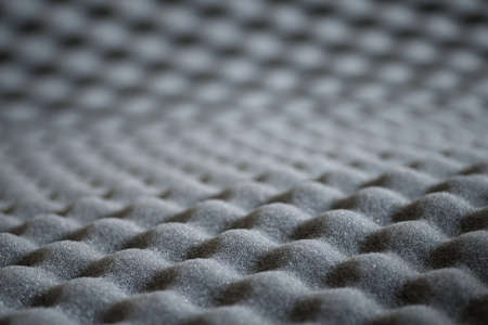 Abstract wavy texture of grey soundproof acoustic foam with selective focus and bokeh backgroundの写真素材