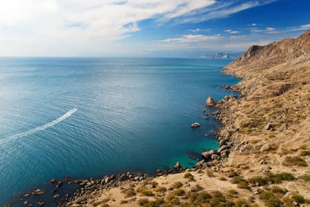View from lighthouse on Meganom cape with little boat in the seaの写真素材
