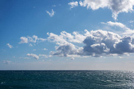 White clouds over a choppy sea in a sunny dayの写真素材