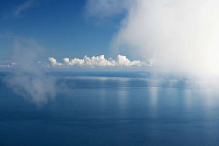 White cloud over blue sea with reflectionの写真素材
