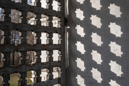 Fragment of a carved wooden gate with a geometric shadowの写真素材