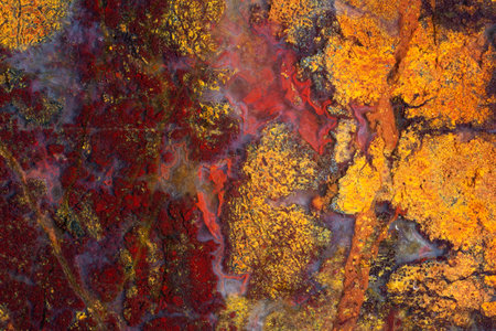 Natural stone background. Full-screen texture of yellow-red Jasper with blue chalcedony inclusions