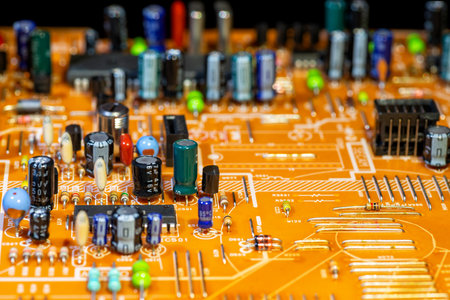 Old orange printed circuit board with multi-colored electronic components, selective focus, blurred...