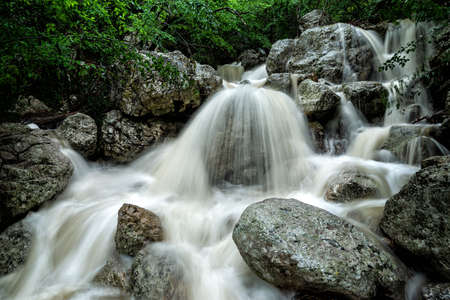 A turbulent forest stream with waterfalls after heavy rainfall in the Crimea.の写真素材